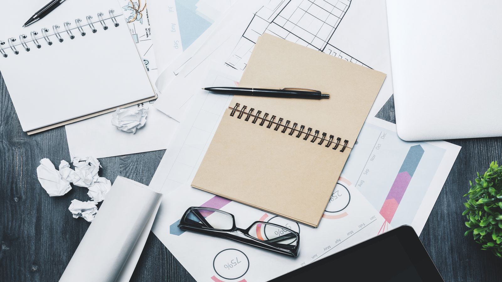 Pracovní stůl s poznámkami, grafy a otevřeným notebookem se záznamy z provozního auditu